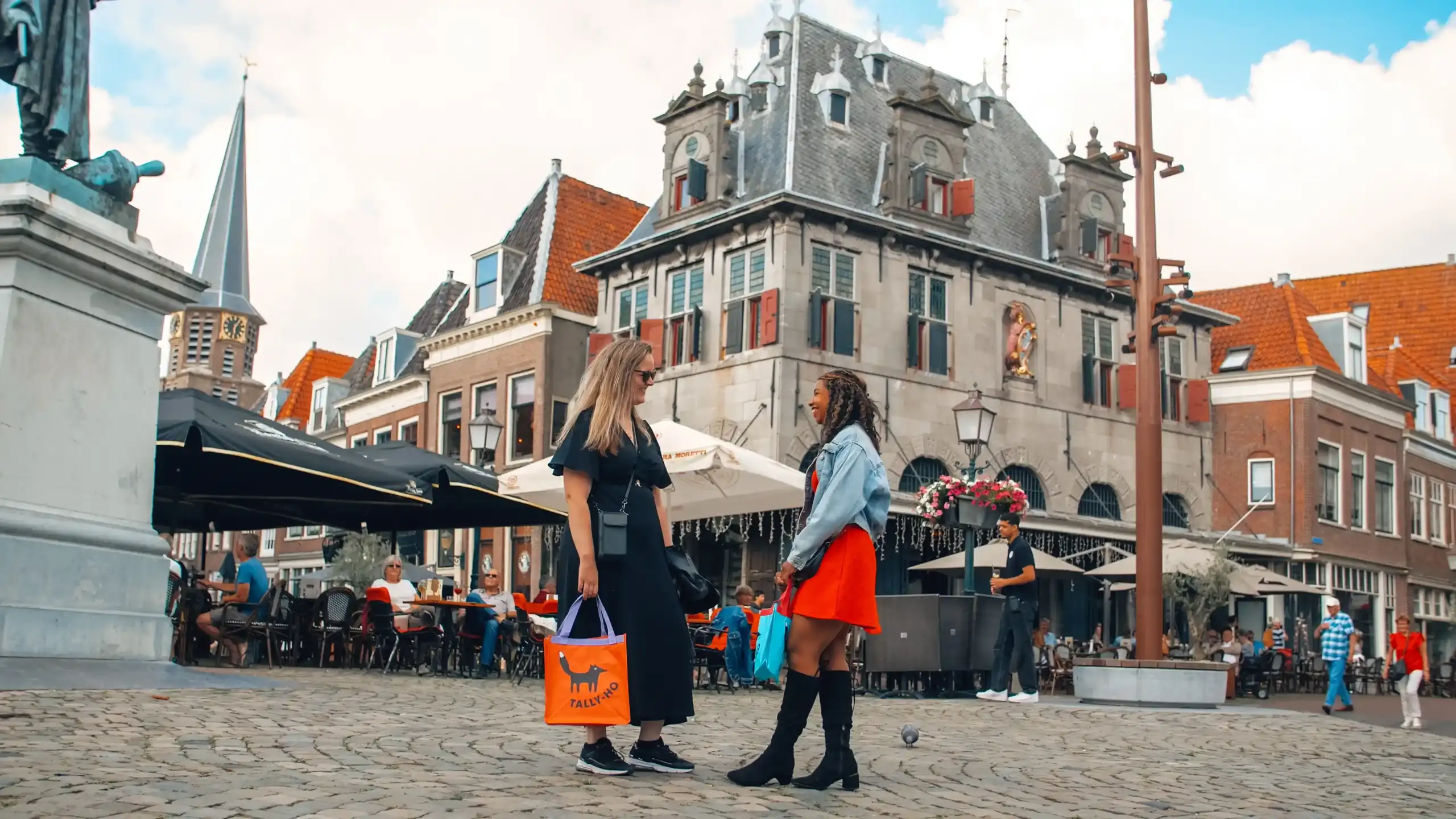Twee vrouwen met kledingtassen in centrum